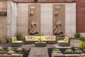 a group of yellow couches in a courtyard at BLU-Tique, Akron, a Tribute Portfolio Hotel in Akron