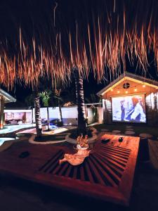 a room with a tv and some palm trees at The White Key Luxury Villas in Gili Trawangan