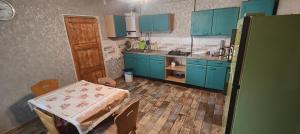 cocina con armarios azules, mesa, mesa y sillas en Villa singola, en Arrinj