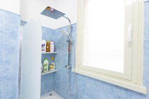 La salle de bains est pourvue d'une douche et de carrelage bleu. dans l'établissement Baglioni Vatican House, à Rome