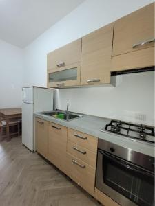 a kitchen with wooden cabinets and a sink and a refrigerator at Luna D'Agerola in Agerola