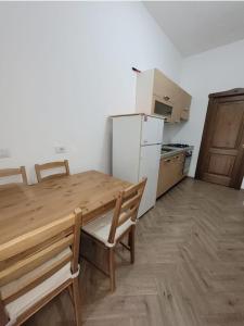 a kitchen with a wooden table and a refrigerator at Luna D'Agerola in Agerola