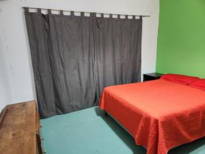 a bedroom with a red bed and a window at LUNA in Comodoro Rivadavia