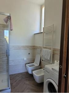 a bathroom with a toilet and a sink and a washing machine at Luna D'Agerola in Agerola