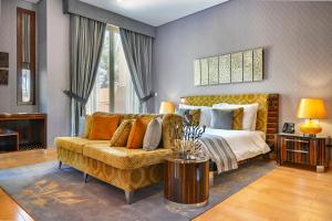 a large bedroom with a bed and a couch at Palavra Resort in Manama