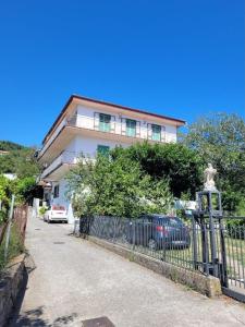 a house with a fence and cars parked in front of it at Luna D'Agerola in Agerola