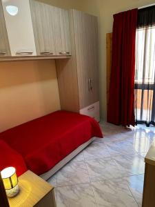 ein Schlafzimmer mit einem roten Bett und einem roten Vorhang in der Unterkunft Casa Del Mare, 3Bedroom House in Marsaxlokk Fishing Village in Marsaxlokk