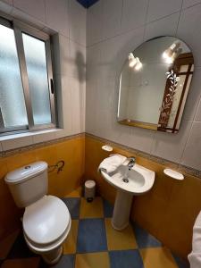 La salle de bains est pourvue de toilettes, d'un lavabo et d'un miroir. dans l'établissement Casa Del Mare, 3Bedroom House in Marsaxlokk Fishing Village, à Marsaxlokk