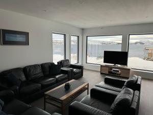 a living room with a couch and a flat screen tv at Arctic Sea Breeze in Kirkenes