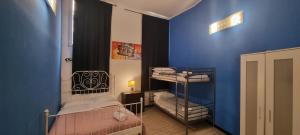 een kamer met 2 stapelbedden en een blauwe muur bij Family Hostel Milano in Milaan