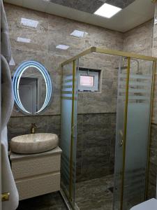 a bathroom with a sink and a shower with a mirror at Sherlock Hotel Baku in Baku