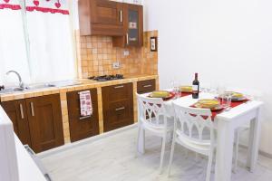 - une cuisine avec une table blanche, des chaises et un évier dans l'établissement Baglioni Vatican House, à Rome