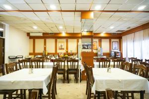 a restaurant with tables and chairs with white table cloth at Hotel Europa in Zagreb