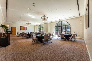 un salón de banquetes con mesas, sillas y ventanas en Sheraton Hotel Stonebriar, en The Colony