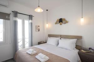 a bedroom with a bed with two towels on it at My White Studio Mykono Town in Mikonos