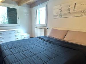 een slaapkamer met een bed, een dressoir en 2 ramen bij La Spezia stazione centrale 5 terre - LOFT in La Spezia