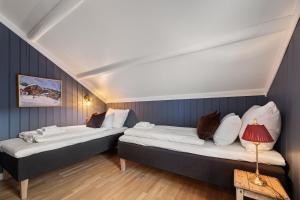 two beds in a room with blue walls at Tuddal Høyfjellshotel in Tuddal