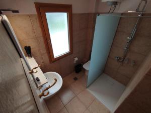 a bathroom with a shower and a toilet and a window at ResidenceTheo in Selianitika