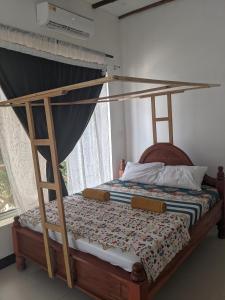 een slaapkamer met een hemelbed en een raam bij Kassandra Beach Hotel in Nungwi