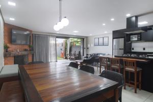 uma cozinha e sala de jantar com uma grande mesa de madeira em Jarda Beach House 50mts do mar na praia Itapeva sul Torres RS em Torres