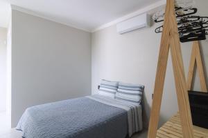 um quarto com uma cama e uma escada de madeira em Jarda Beach House 50mts do mar na praia Itapeva sul Torres RS em Torres