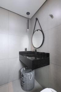 uma casa de banho com um lavatório preto e um espelho em Jarda Beach House 50mts do mar na praia Itapeva sul Torres RS em Torres