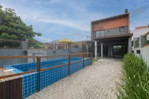 uma imagem de uma casa com piscina em Jarda Beach House 50mts do mar na praia Itapeva sul Torres RS em Torres