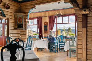 a woman sitting at a table in a restaurant at Tuddal Høyfjellshotel in Tuddal