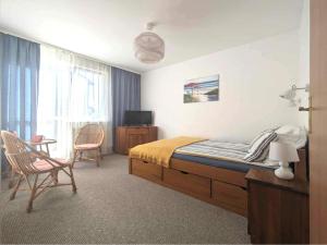 1 dormitorio con 1 cama, mesa y sillas en FLORIAN - tuż przy plaży, en Mielno