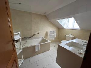 ein Badezimmer mit einer Badewanne und einem Waschbecken in der Unterkunft Auberge De La Gaichel in Gaichel