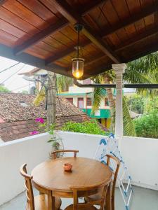 a wooden table and chairs on a porch with a wooden ceiling at No 31 in Galle