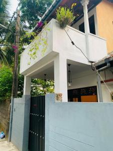 a white house with a gate and a fence at No 31 in Galle