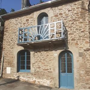 Maison de charme : Ti Pauline. في دينان: مبنى حجري مع شرفة وباب ازرق