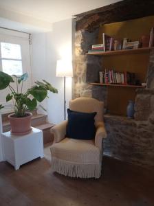 Maison de charme : Ti Pauline. في دينان: غرفة معيشة بها كرسي وزرع الفخار