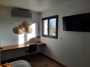 a room with a desk and a window and a television at Petit coin de paradis, calme et confort garantie ! in Montauban