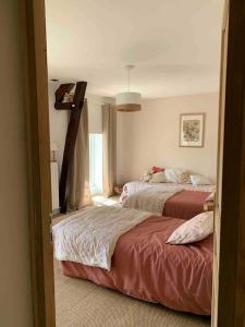 1 dormitorio con 2 camas y ventana en La Pageotière: une longère normande, en Saint-Denis-sur-Sarthon