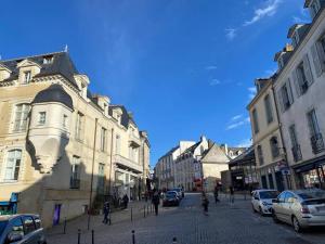 una calle de la ciudad con edificios y gente caminando por la calle en Appartement Intra murailles, en Vannes