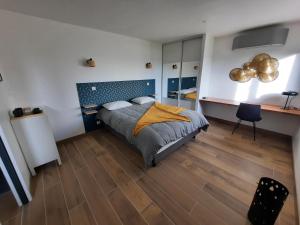 - une chambre avec un lit et du parquet dans l'établissement Petit coin de paradis, calme et confort garantie !, à Montauban