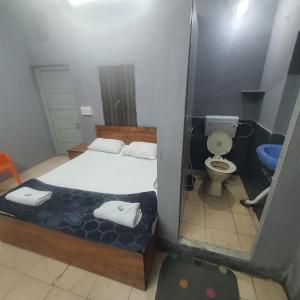 um pequeno quarto com uma cama e um WC em Hotel Family Stay em Aurangabad