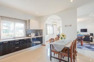 a kitchen and dining room with a table and chairs at The Cactus Pool Villa Pattaya in Ban Huai Yai