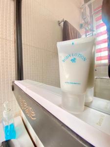 Una botella de jabón en un estante del baño en Bays Villa, en Koforidua