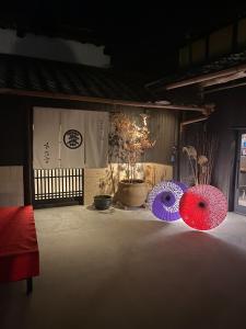 zwei rote und blaue Regenschirme auf einem Tisch in der Unterkunft Irori no Yado Kinoko - Vacation STAY 76611v in Sakaide