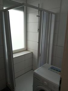 a bathroom with a window and a washing machine at Maria Zimmer im UG Neu und Modern in Heilbronn