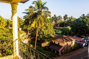 a view from a balcony of a town with palm trees at Cosmos Inn in Goa