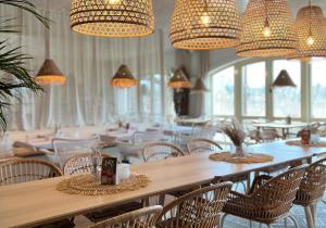 a large room with tables and chairs and chandeliers at Strandhaus Hotel in Parey