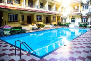 a large swimming pool in front of a building at Cosmos Inn in Goa