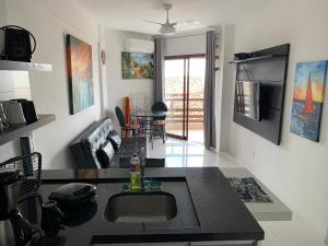 una cucina e un soggiorno con un lavandino e un divano di Apartamento com Vista do Mar em Residencial com Piscina a Florianópolis