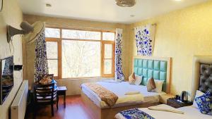 a bedroom with two beds and a window at Hotel River View Resort in Pahalgām