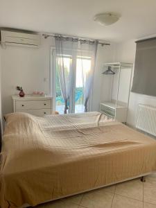 a large bed in a bedroom with a large window at Flat Panorama Sea View Studio for Couples Vrachos in Preveza