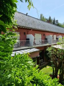 an exterior view of a red building with balconies at Hotel de la Gaichel in Eischen